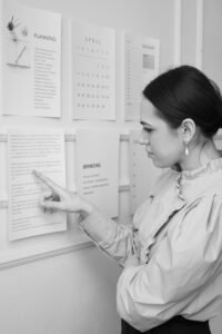 Woman pointing to a piece a paper on a board 